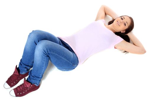 Attractive teenage girl lying on floor. All on white background.