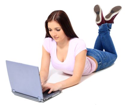 Attractive teenage girl lying on the floor, using notebook computer. All on white background.