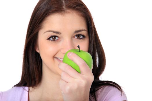Attractive teenage girl eating an apple. All on white background.