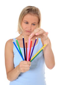 Attractive young scandinavian woman choosing colored pencil. All on white background.