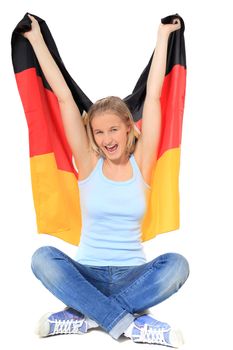 Attractive teenage girl cheering with german flag. All on white background.