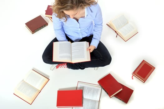 Attractive young girl reading books. All on white background.