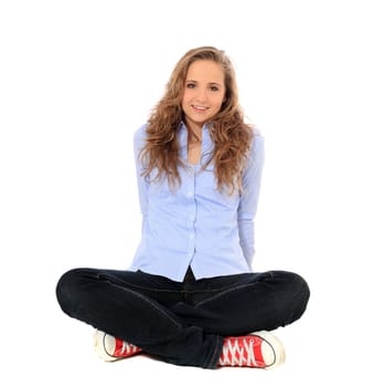 Attractive young girl sitting on the floor. All on white background.