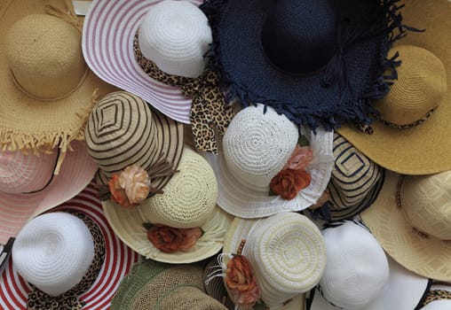 Close-up image of a street stand selling various types of summer hats.