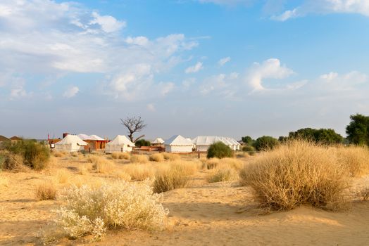 Tent camping site hotel for tourist  in the thar desert under blue sky