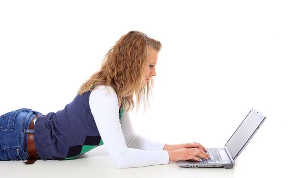 Attractive young woman lying on floor using notebook computer. All on white background.