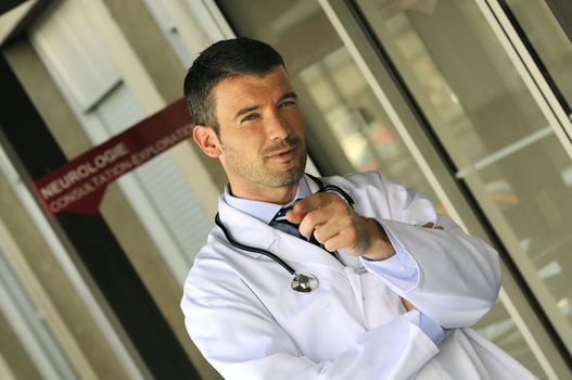 portrait of doctor in front an entrance of the hospital