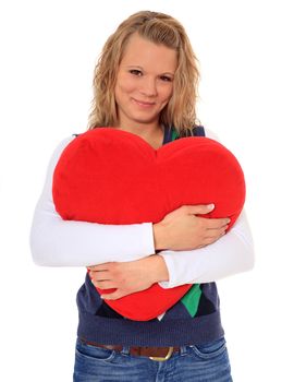 Attractive blonde woman hugging a heart-shaped pillow. All on white background.