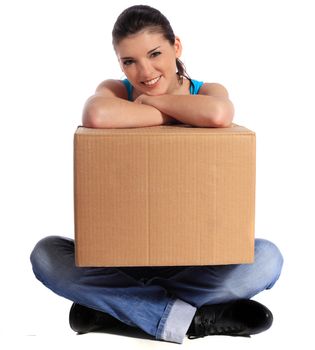 Attractive young woman sitting on floor holding moving box. All on white background.