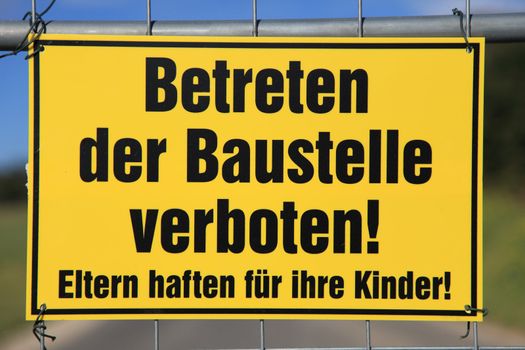 Yellow warning sign in front of construction sign in german lnaguage that says. Do not enter, construction site.