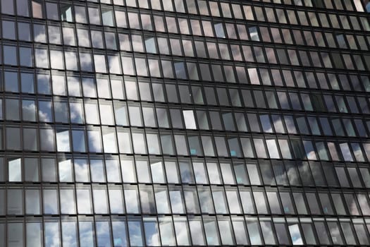 Cloudy sky reflects in a glassy house front