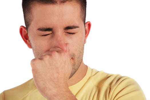 Attractive young man holding his nose. All isolated on white background.