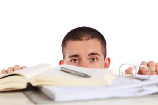 Attractive young man looking behind his study documents. All isolated on white background.