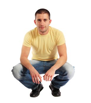 Attractive young man in squatting position. All on white background.