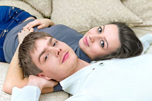 young guy and a girl lying on the couch