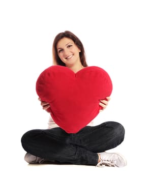 Attractive young woman holding a heart-shaped pillow. All on white background.