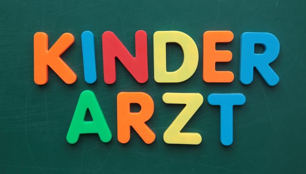 German term for pediatrician in colorful letters on a blackboard.