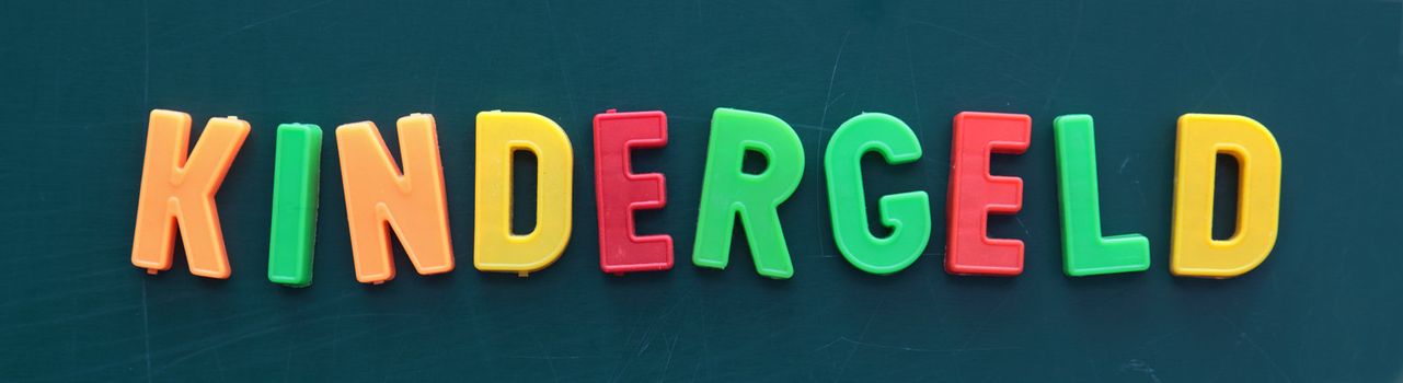 The german term for child allowance in colorful letters on a blackboard.