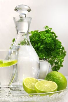 Fresh limes and water with glass container and water glass