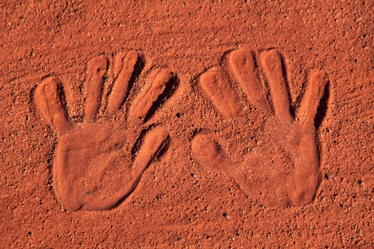 Handprints in typical red sand of central Australia.