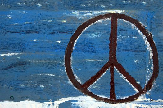 Peace sign painted on wooden board.