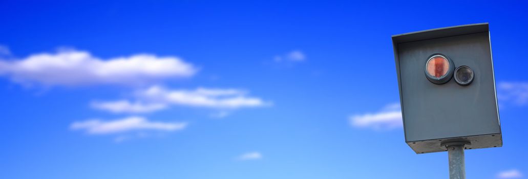 A typical radar trap in front of bright blue sky. Image format as banner.