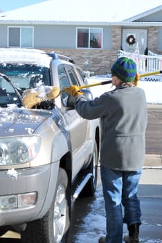 Female clearing snow off her suv.