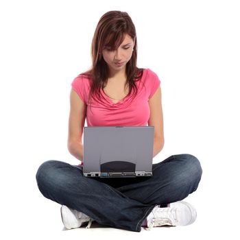 An attractive young woman sittin g cross-legged while surfing the internet on her notebook computer. All on white background. 