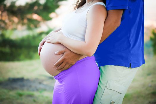 Pregnant woman holding hands around her belly 