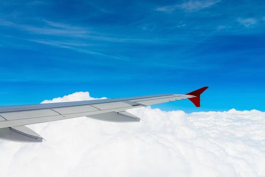 Blue sky and white clouds with airplane wing