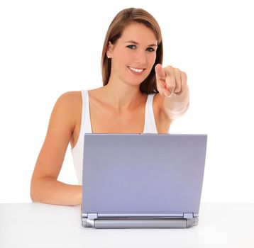 Attractive young woman points with finger while working at laptop. All on white background.