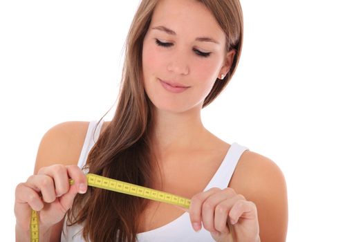 Attractive young woman looking at measuring tape. All on white background.