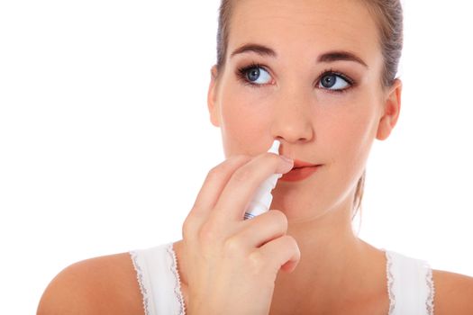 Attractive young woman using nasal spray. All on white background.