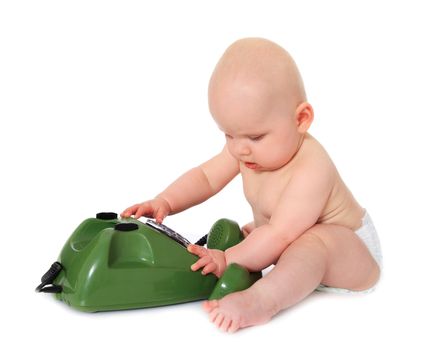 Newborn child playing with a green telephone. All isolated on white background.