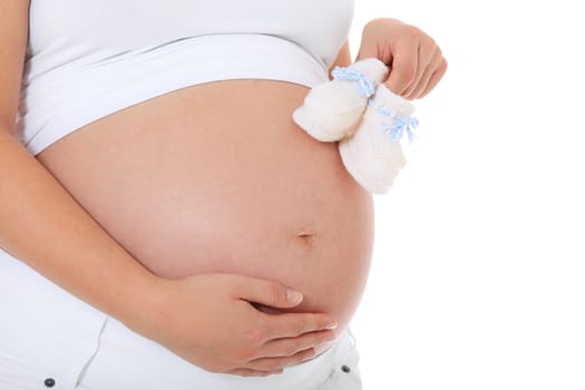 Pregnant woman holding baby shoes. All on white background.