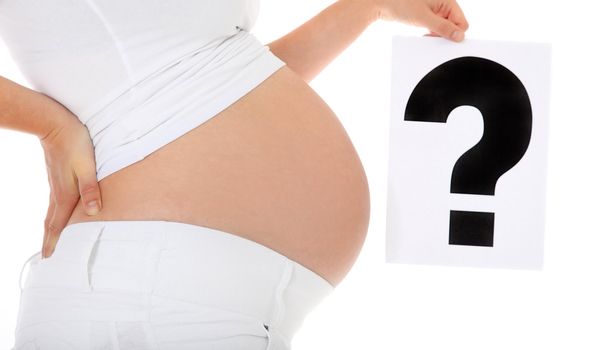 Pregnant woman holding big question mark. All on white background.