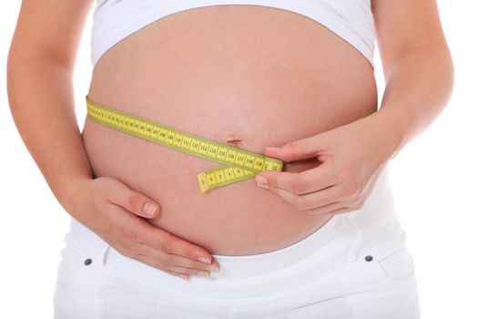 Pregnant woman measuring her belly. All on white background.