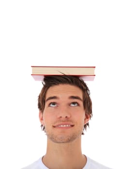 Attractive young man balancing a book on his head. Extra copy space on top. All on white background.