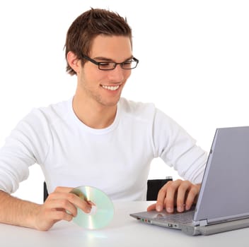 Smiling young guy using notebook computer. All on white background.