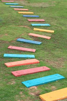 Colorful Wooden Walkway and Pathway in the Green garden grass fields