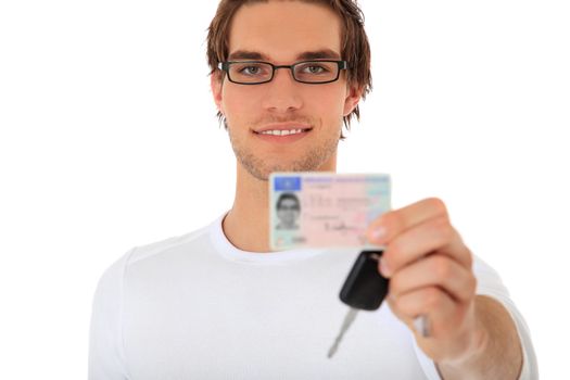 Young guy showing his drivers license and car keys. Selective focus on person in background. License details are blurred out. All on white background.