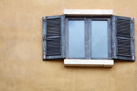 Open Wooden windows in Italian style on yellow building