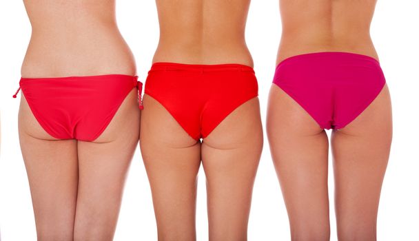 Backside of three attractive women in bikini. Isolated on white background.