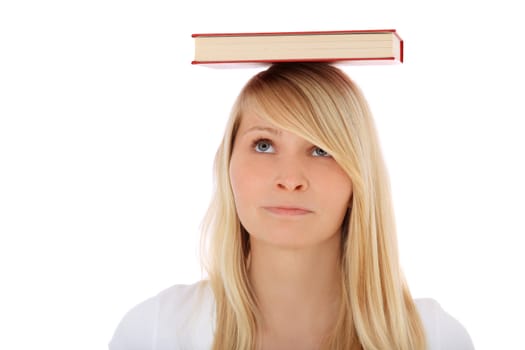 Attractive teenage girl balancing a book on her head. All on white background.