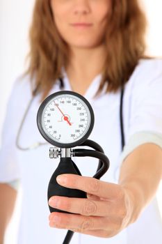 Competent female doctor. Selective focus on blood pressure equipment in foreground. All on white background.