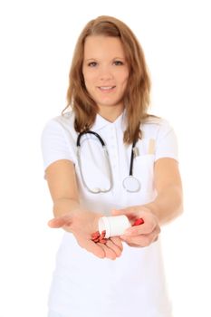 Confident doctor holding some pills. All on white background.