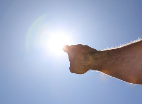 A person pointing with finger to the sun.