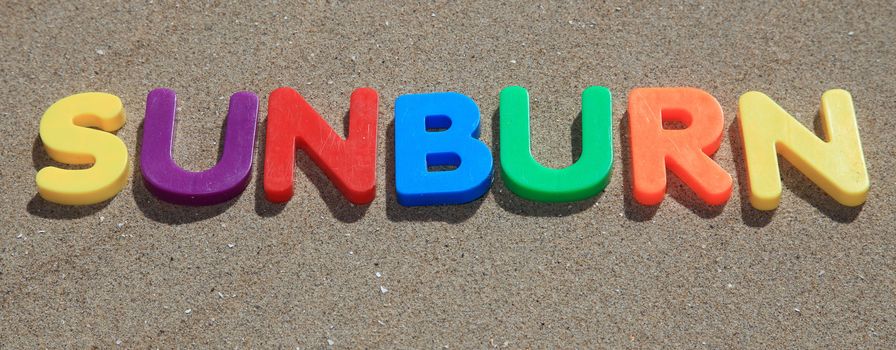The term sunburn written in colorful letters on sand.