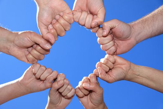 Various peoples hands in front of bright blue sky forming a cycle.