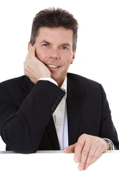 Attractive middle-aged man standing behind blank white wall. All on white background.